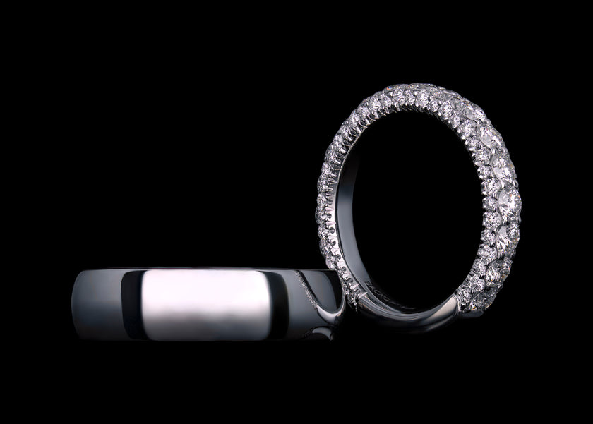 Platinum wedding band set featuring a solid platinum band and a pavé three-sided diamond band.