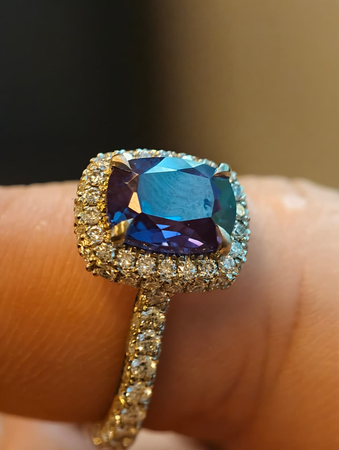 Student finished worked of a three-sided halo ring with a blue gemstone center stone