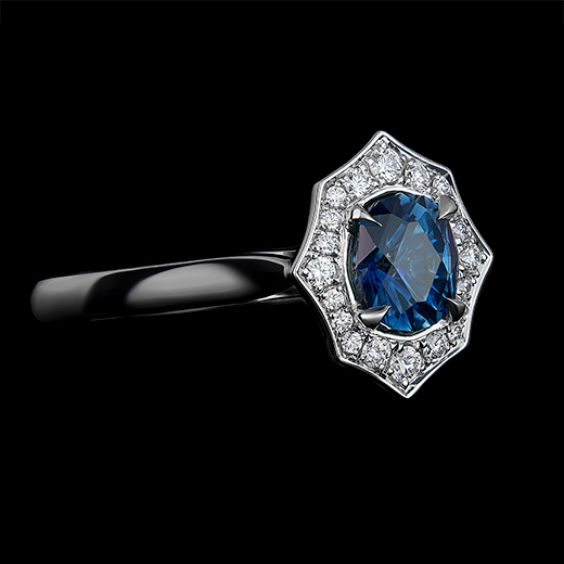 0.89 CT Oval blue sapphire center stone set in 4 talon claws. Surrounded by diamonds in a bright cut halo, made in a platinum mount.