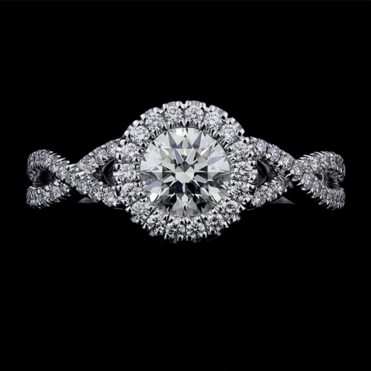 0.62 CT Round brilliant cut diamond center stone set in a clawless halo with diamonds. Accented by a ribbon style shank with u-set diamonds in a 14k white gold mount.
