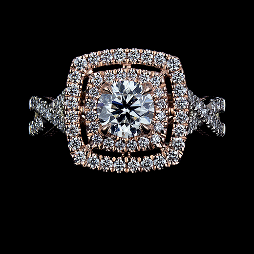 0.64 CT Round brilliant cut diamond set in 4 talon claws. Surrounded by a double halo of round diamonds in u-setting. Accented by a ribbon style shank with u-set diamonds. The mount is made in 14k rose and 14k white gold.