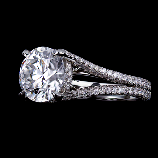 2 CT Round brilliant cut diamond center stone set in 4 talon claws. Accented by a 3 sided pave hidden halo, as well as a split shank with 3 sided pave blending into the center prongs. Mount made in platinum.