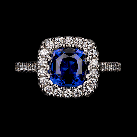 2.05 CT Cushion cut blue sapphire center stone set in a clawless halo with round diamonds. Accented by diamonds u-set on the shank, made in a platinum mount.