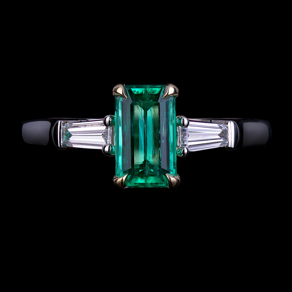 1.05 CT Emerald center stone accented by tapered baguette diamonds in 18k white and yellow gold.
