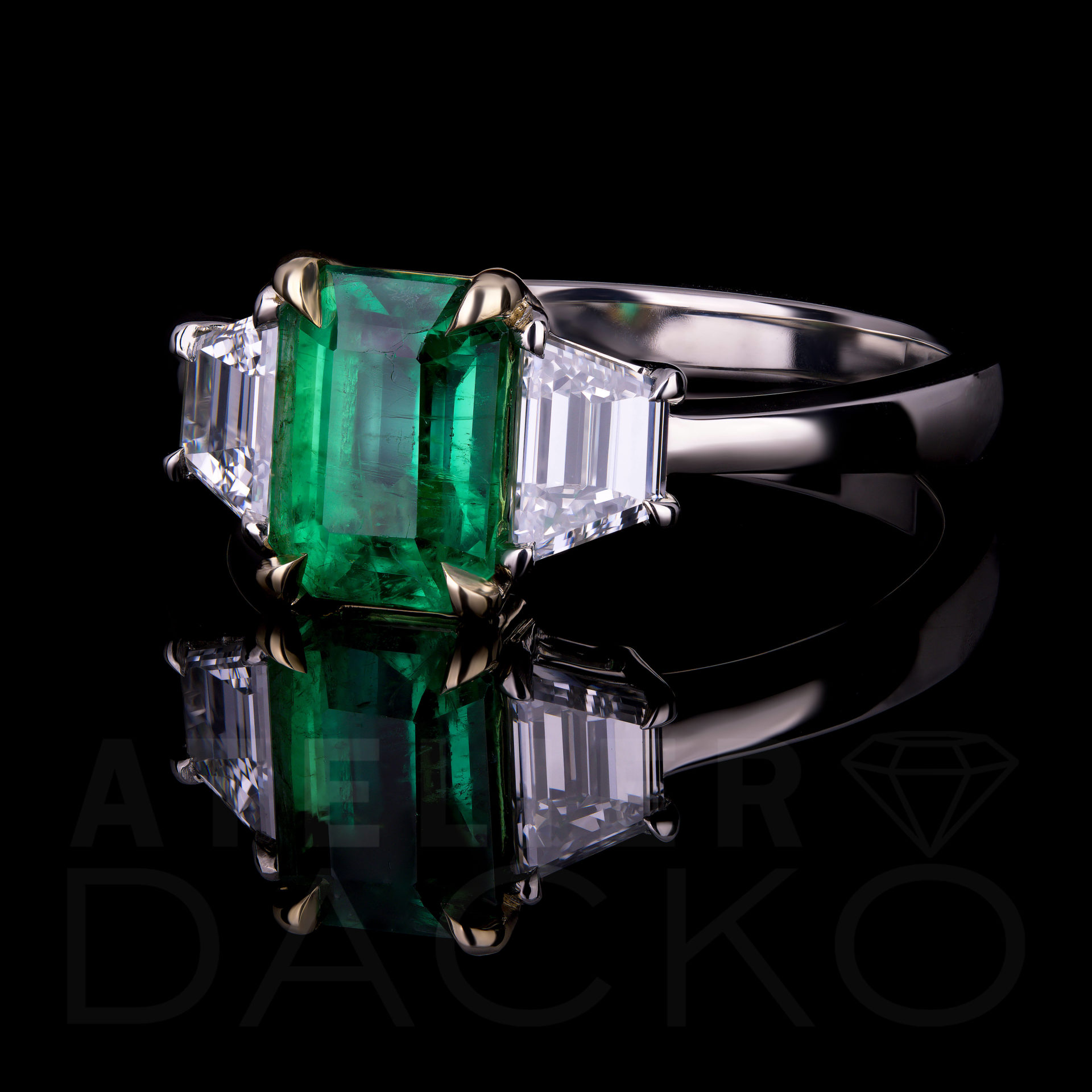 1.50 CT Emerald Ring With Trapezoid Diamonds In Three-Stone Setting